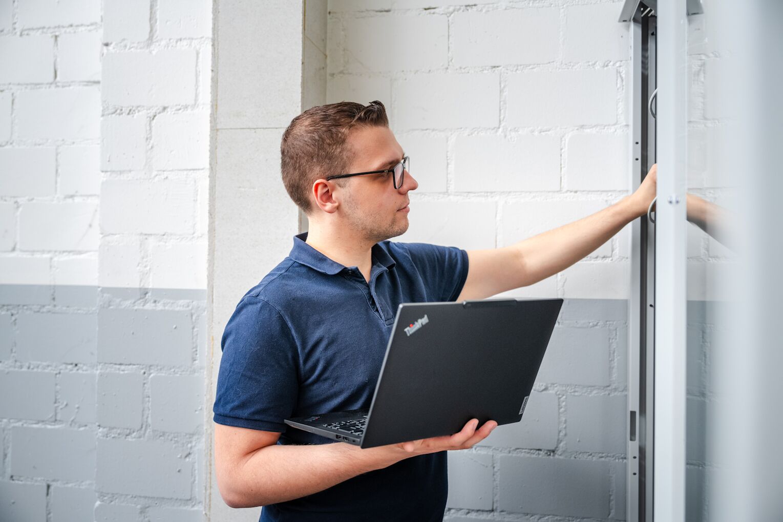 IT-Techniker der Brogli Informatik prüft einen Serverschrank beim Kunden vor Ort